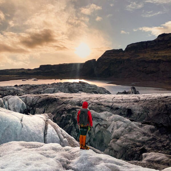 person hiking on the glacier midnight sun