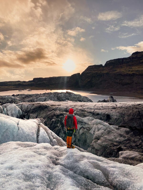 person hiking on the glacier midnight sun