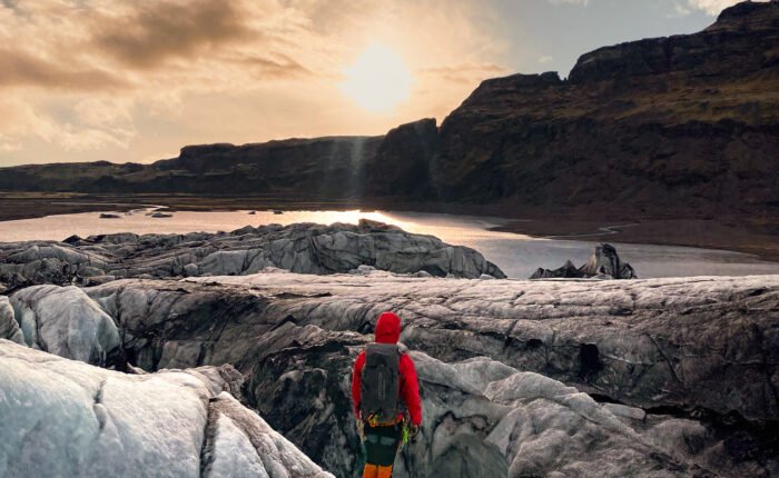 person hiking on the glacier midnight sun