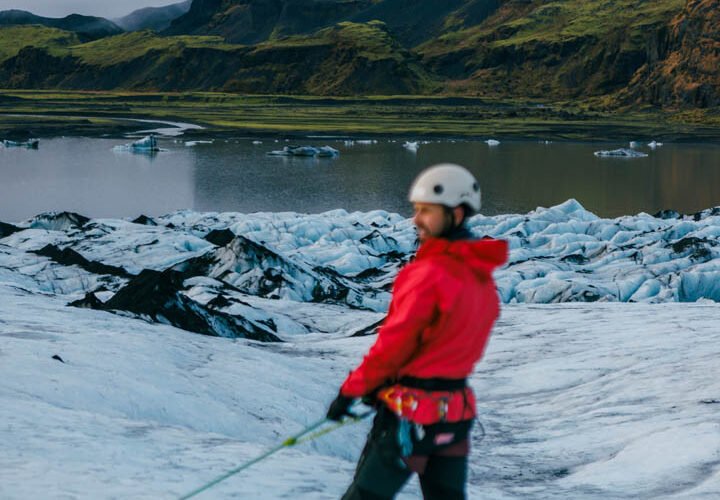 2M8A2013 glacier guide belaying person climbing moulin in Iceland