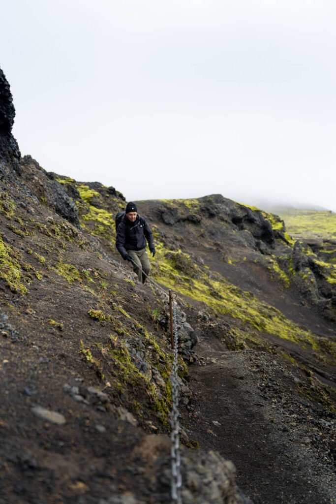 Hiker walking along an exposed ridge on the Fimmvörðuháls trail