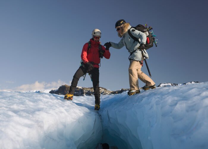 Screenshot glacier guide helping customer to go over crevasse on sólheimajökull